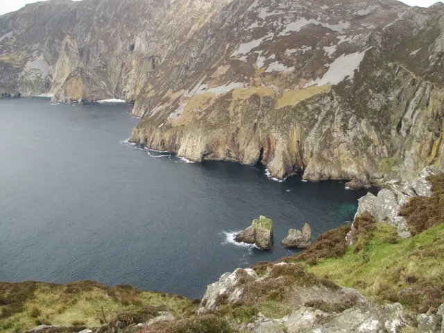 a body of water with mountains around it with Slieve League in the background