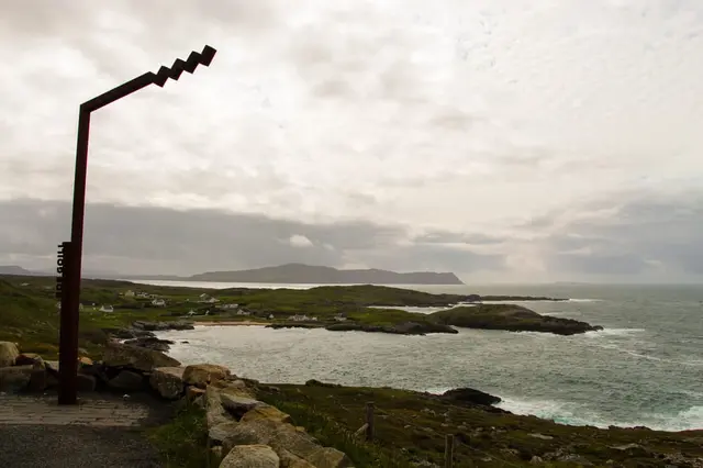 a rocky beach with a body of water in the background