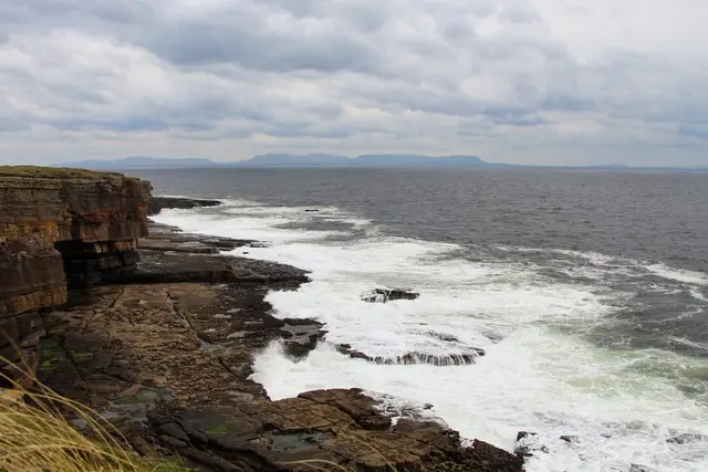 a rocky beach with waves crashing against it