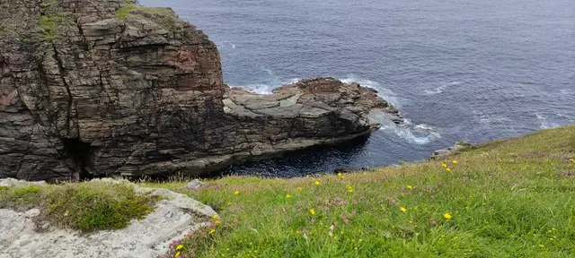 a cliff next to a body of water