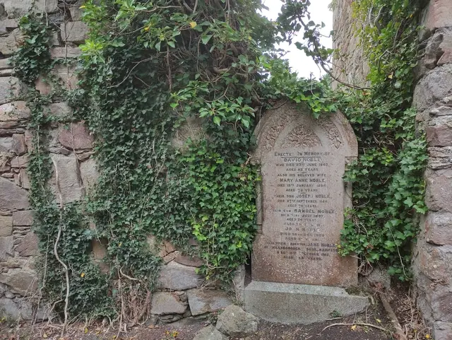 a tombstone in a stone wall