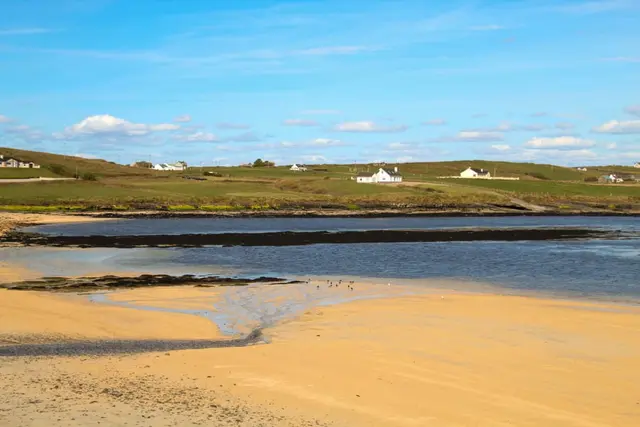 a beach with a house in the distance