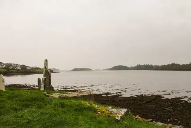 a body of water with grass and rocks by it