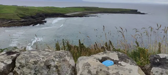 a body of water with rocks and grass around it