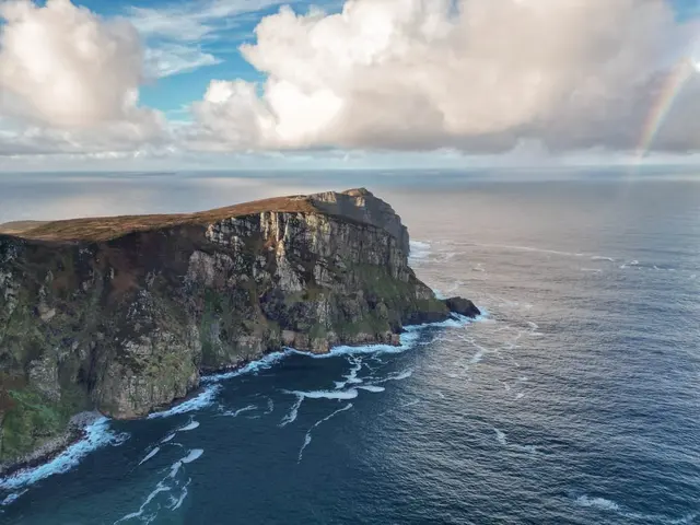 a rainbow over a cliff