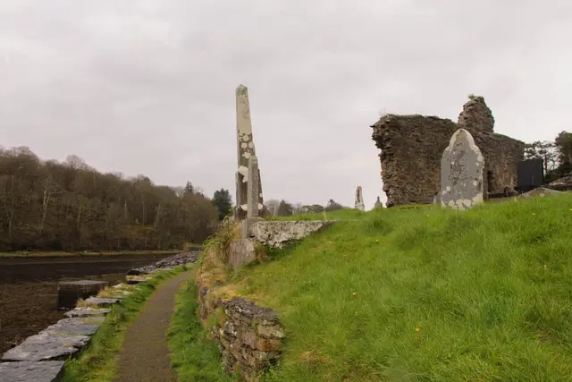 a stone structure on a grassy hill