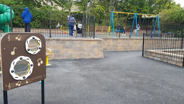 a playground with a fence and people
